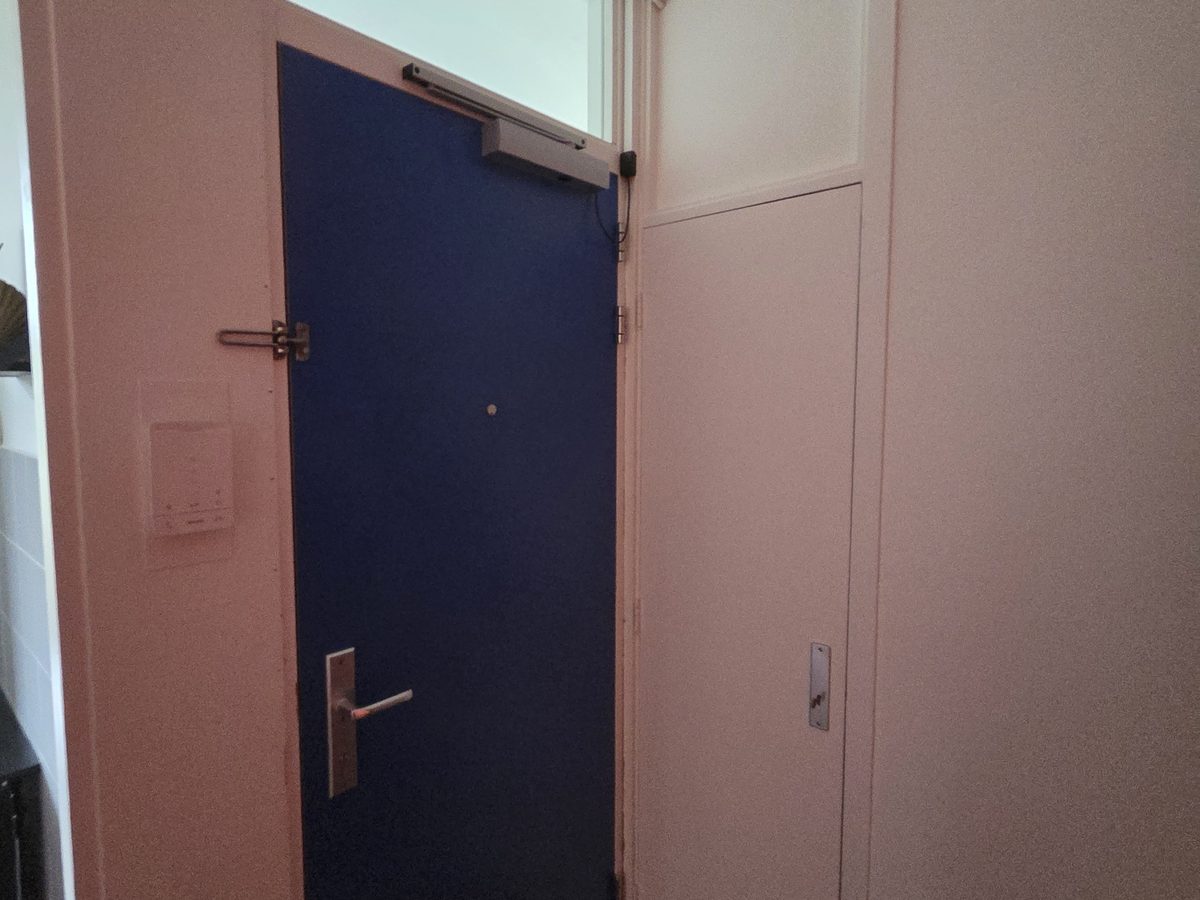 Voordeur en meterkastdeur in een portiek na de renovatie