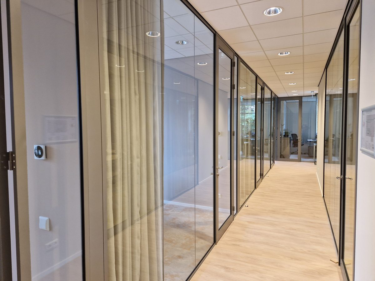 Glazen wanden langs een kantoorgang in een gemeentehuis