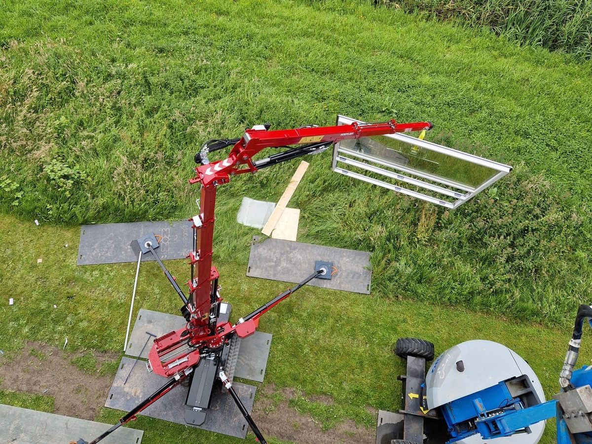 Minikraan zet glazen puien achter een gebouw in Alkmaar