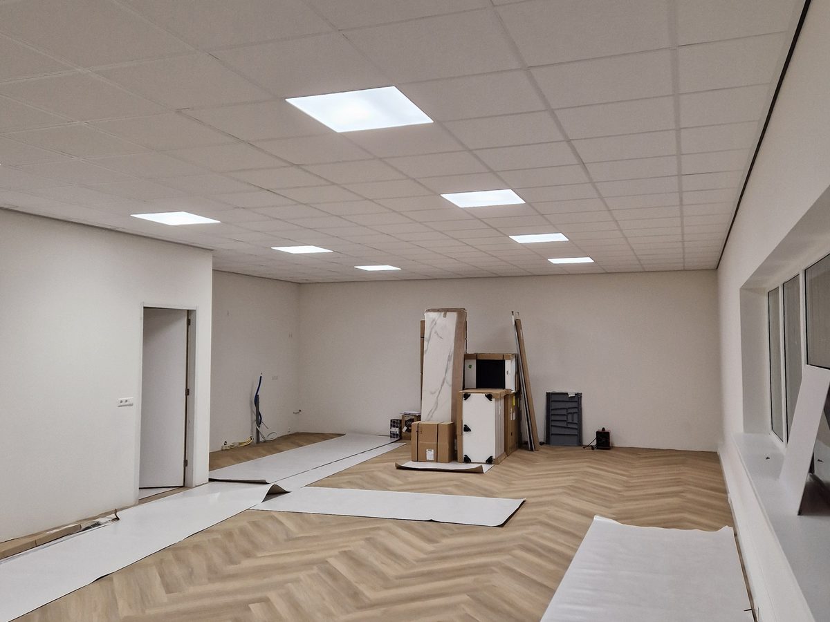 Systeemplafond met ledpanelen boven een visgraatvloer